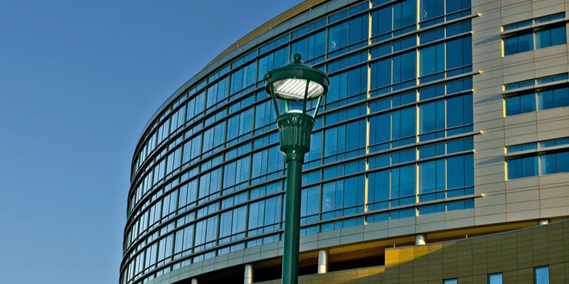 A post-top LED lantern light from Holophane lights the outdoor area of an office building.