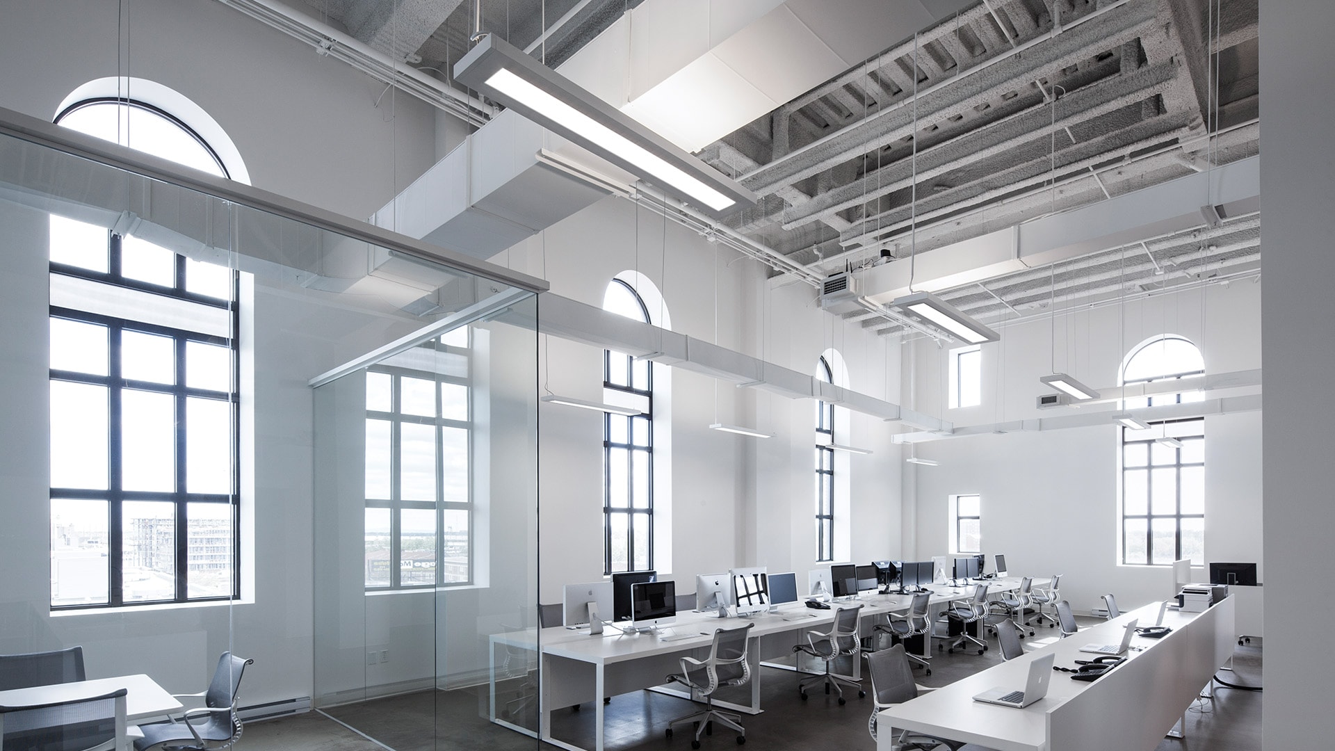 Open ceiling office makes use of Peerless Bruno low profile lights