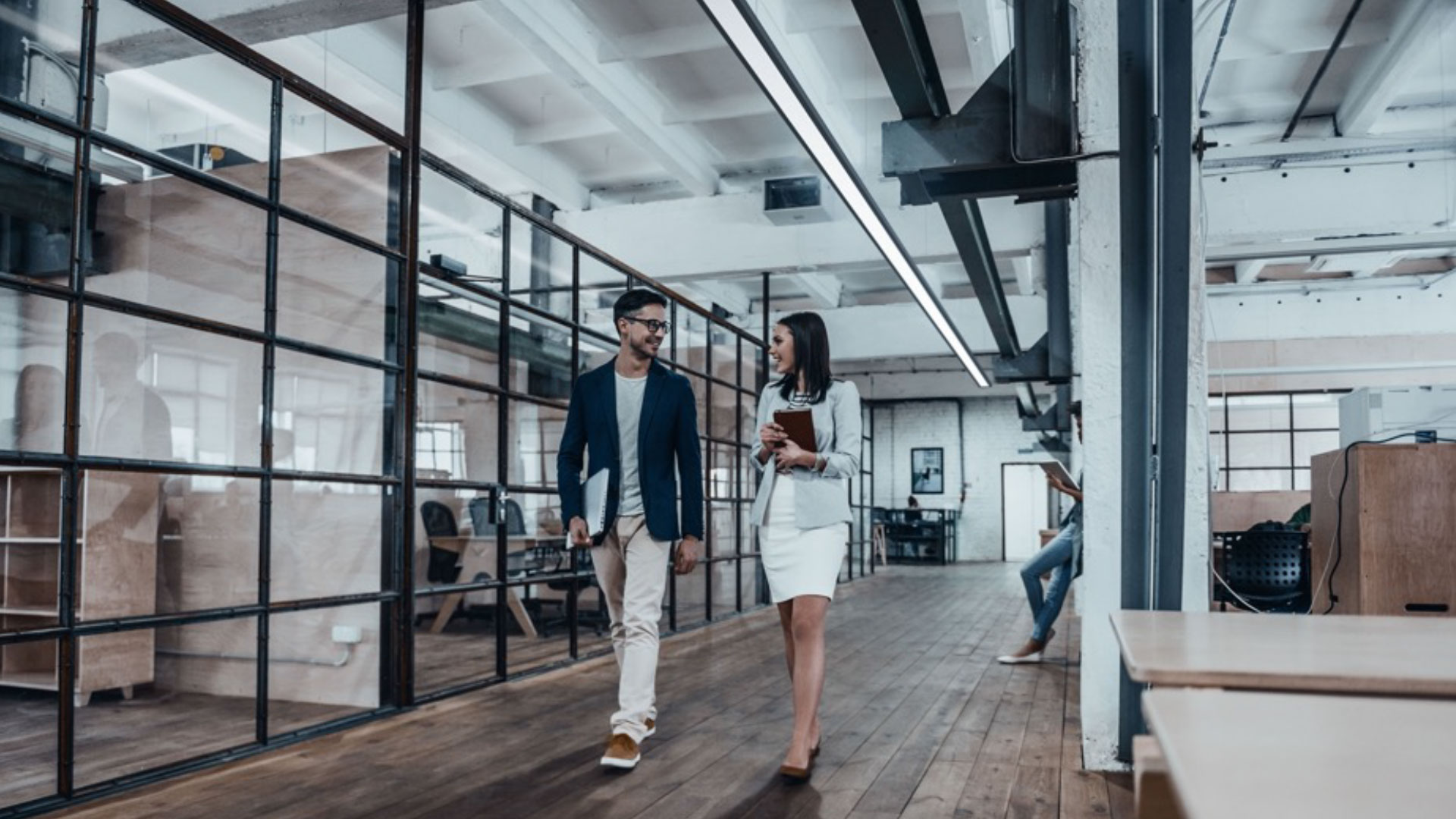 Proper suspended linear fixtures from Peerless illuminate walking spaces in an office.